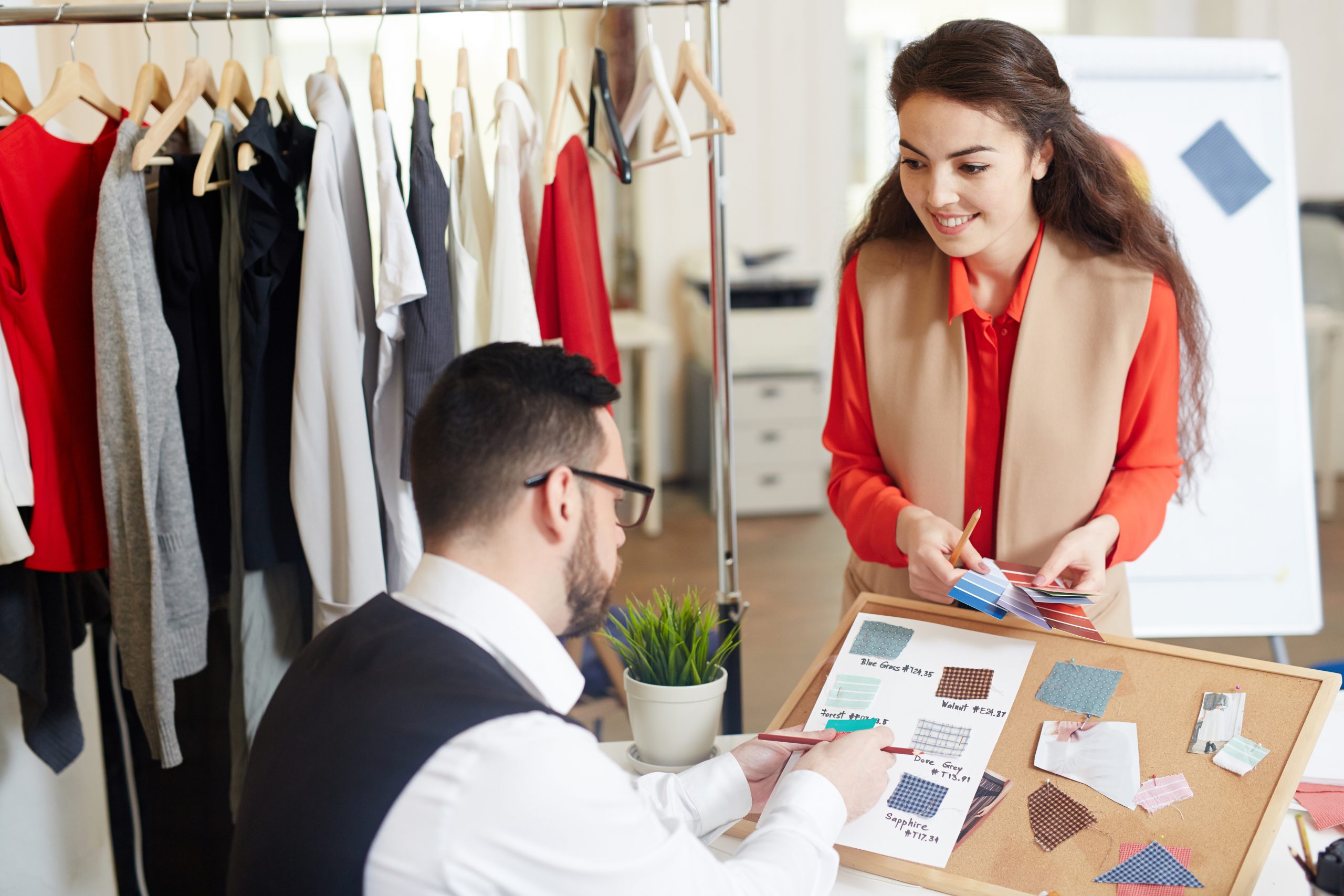 Fashion designers consulting while discussing trendy colors and fabrics